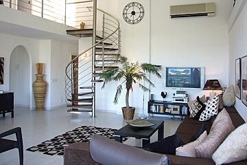 A living room with a spiral staircase and a clock on the wall