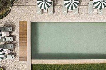 An aerial view of a swimming pool with chairs and umbrellas