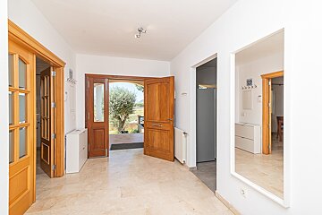A hallway with a wooden door and a mirror