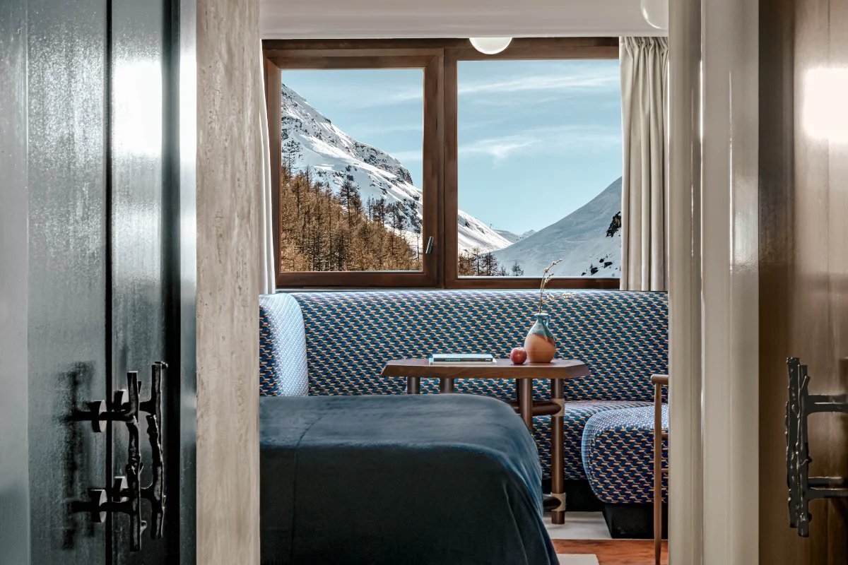 A bedroom with a view of a snowy mountain