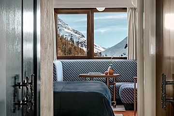 A bedroom with a view of a snowy mountain