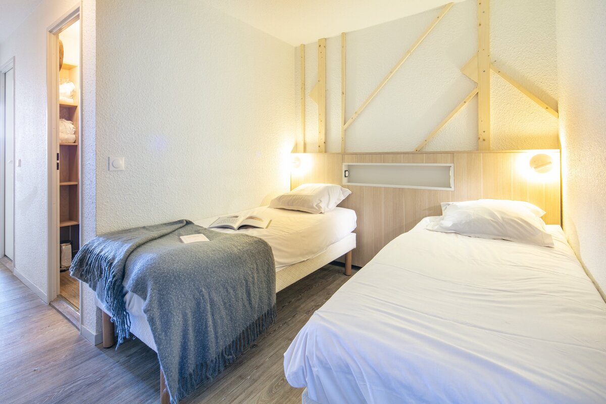 A bedroom with two beds and a book on the bed