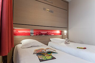 A bedroom with two beds and a book that says ' disney ' on it