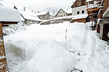 A snowy village with a yellow pole in the middle
