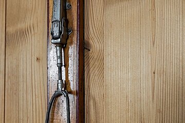 A close up of a piece of metal on a wooden wall