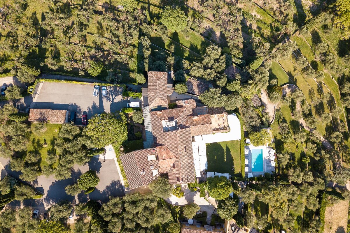 An aerial view of a large house surrounded by trees