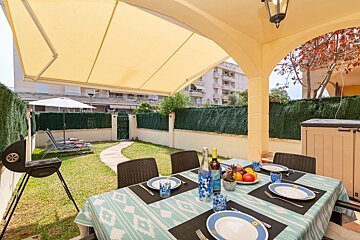A table with plates and utensils on it and a bottle of wine on it