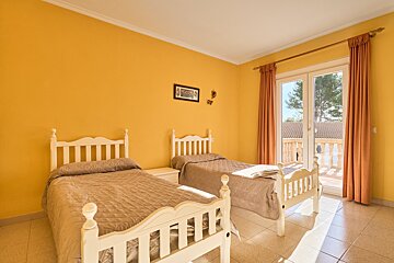 A bedroom with two beds and a picture on the wall