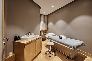 A room with a massage table and a sign that says dx