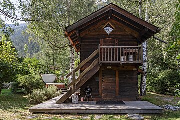 A small wooden house with stairs leading up to it