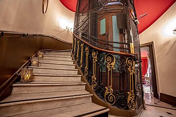A staircase with a wrought iron railing and candles on the steps