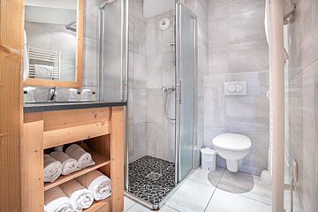 A bathroom with a walk in shower and a toilet
