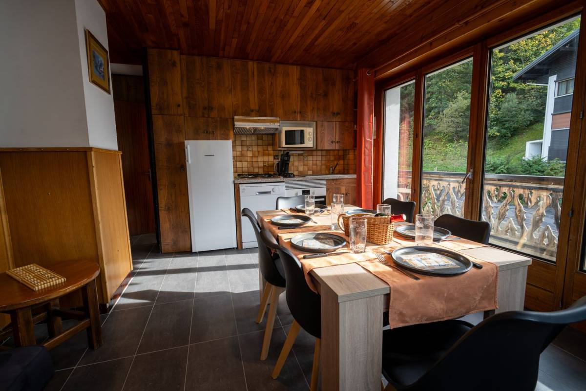 A kitchen with a table and chairs and a dishwasher