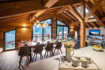 A dining room with a large table and chairs