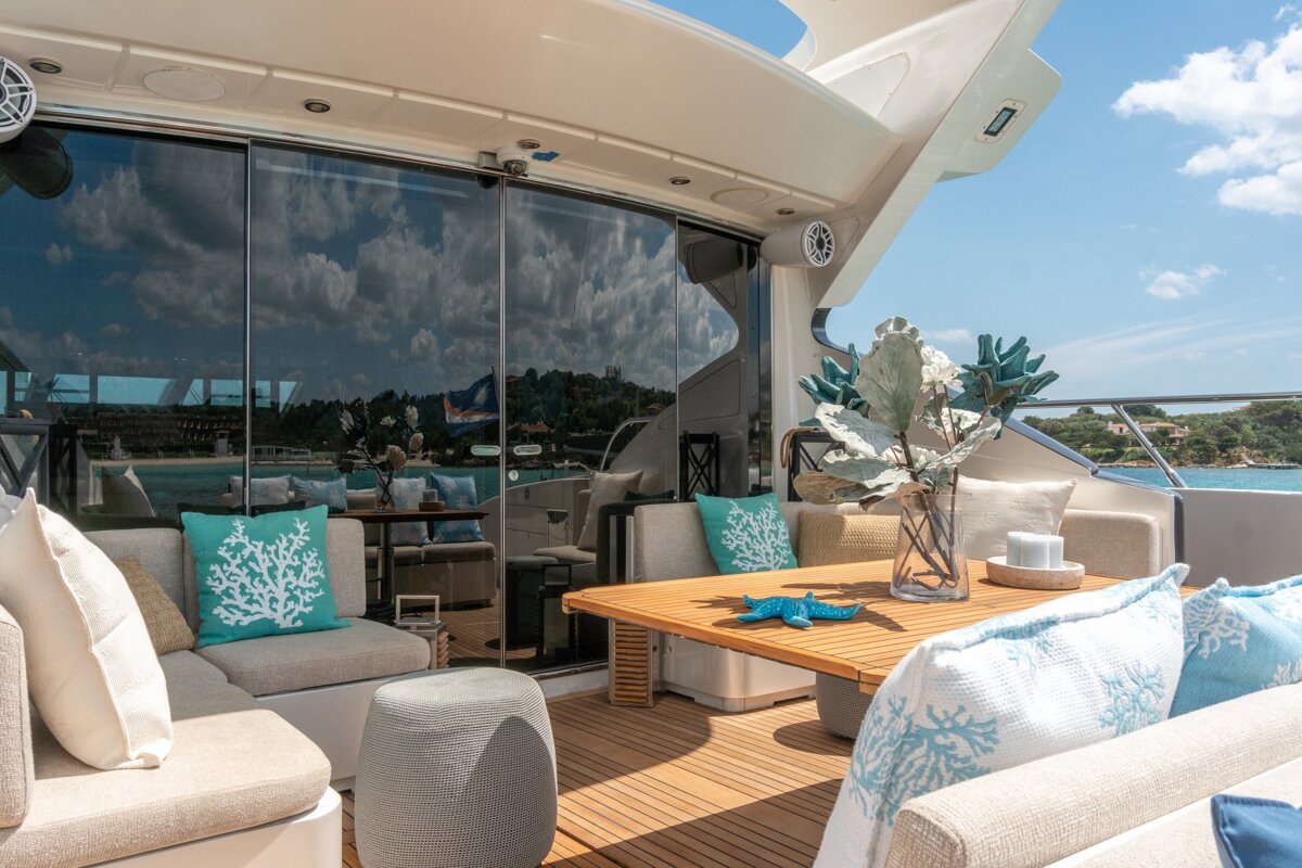 A boat with a table and couch with coral pillows