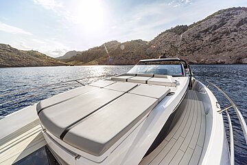 A boat is floating on a body of water with mountains in the background