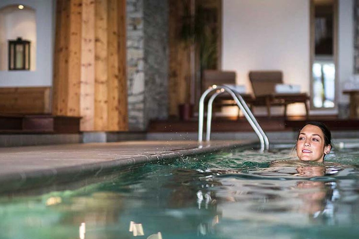 A woman is swimming in an indoor swimming pool