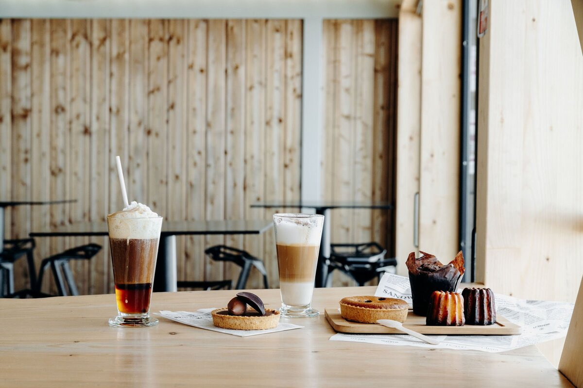 A tray of pastries and drinks on a table with a newspaper that says ' l' avenir ' on it