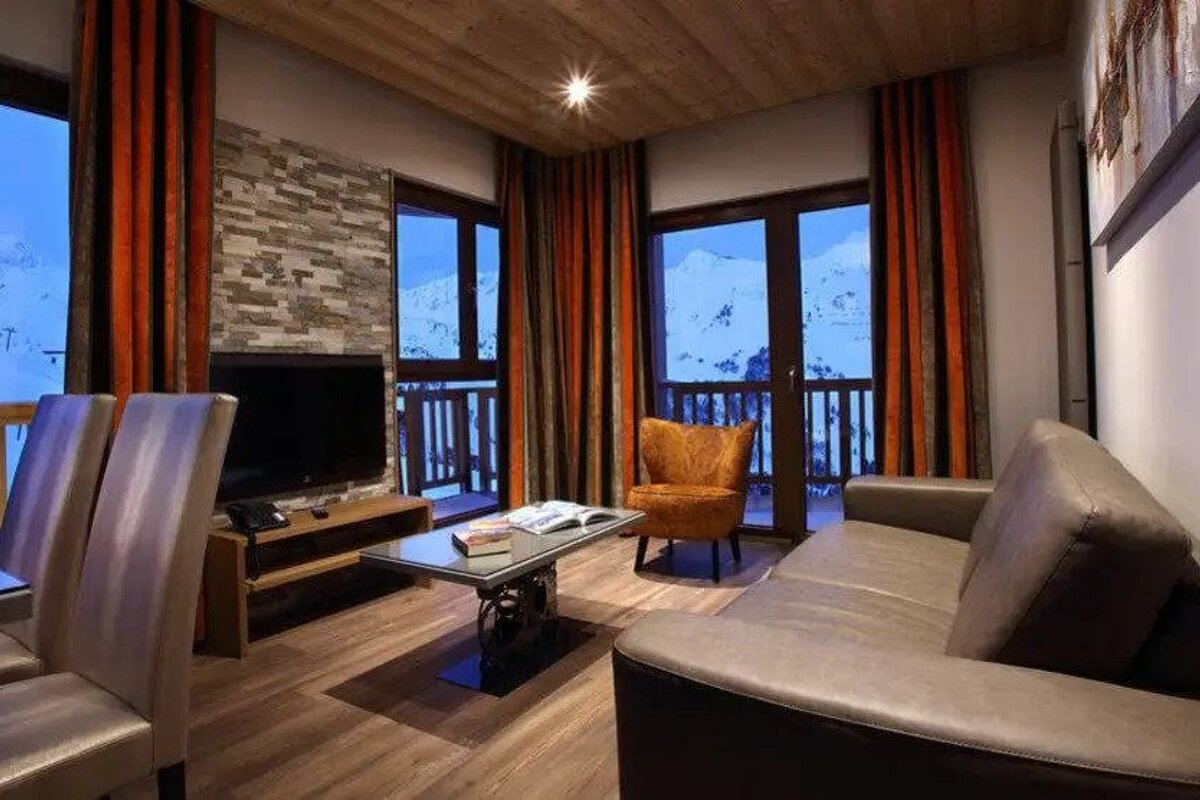 A living room with a couch , chair , table and television