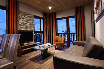 A living room with a couch , chair , table and television