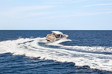 A boat is speeding through the ocean and making waves