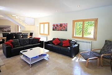 A living room with a black leather couch and a white coffee table