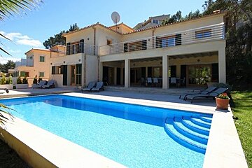 A large house with a large swimming pool in front of it