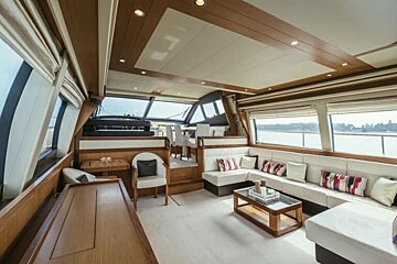 A living room on a yacht with a couch , table and chairs
