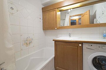 A bathroom with a washing machine and a sink
