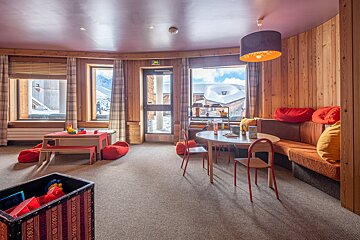 A room with tables and chairs and a large window