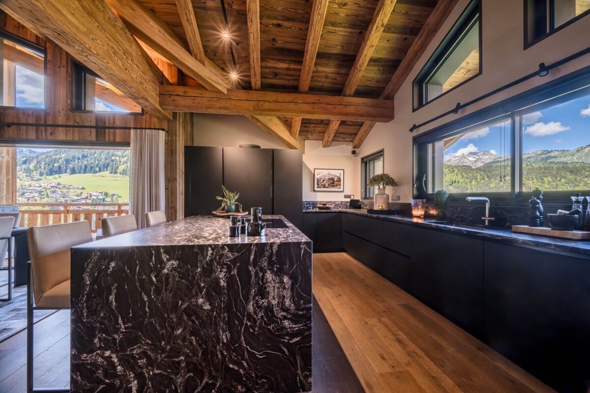 A kitchen with a marble counter top and a view of the mountains