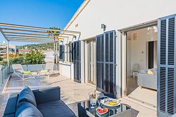 A balcony with a couch and a table with a plate of food on it