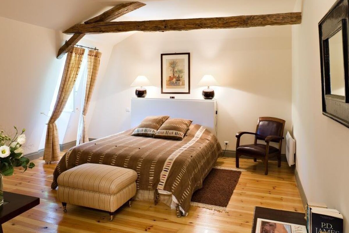 A bedroom with a bed a chair and a book titled old rd james