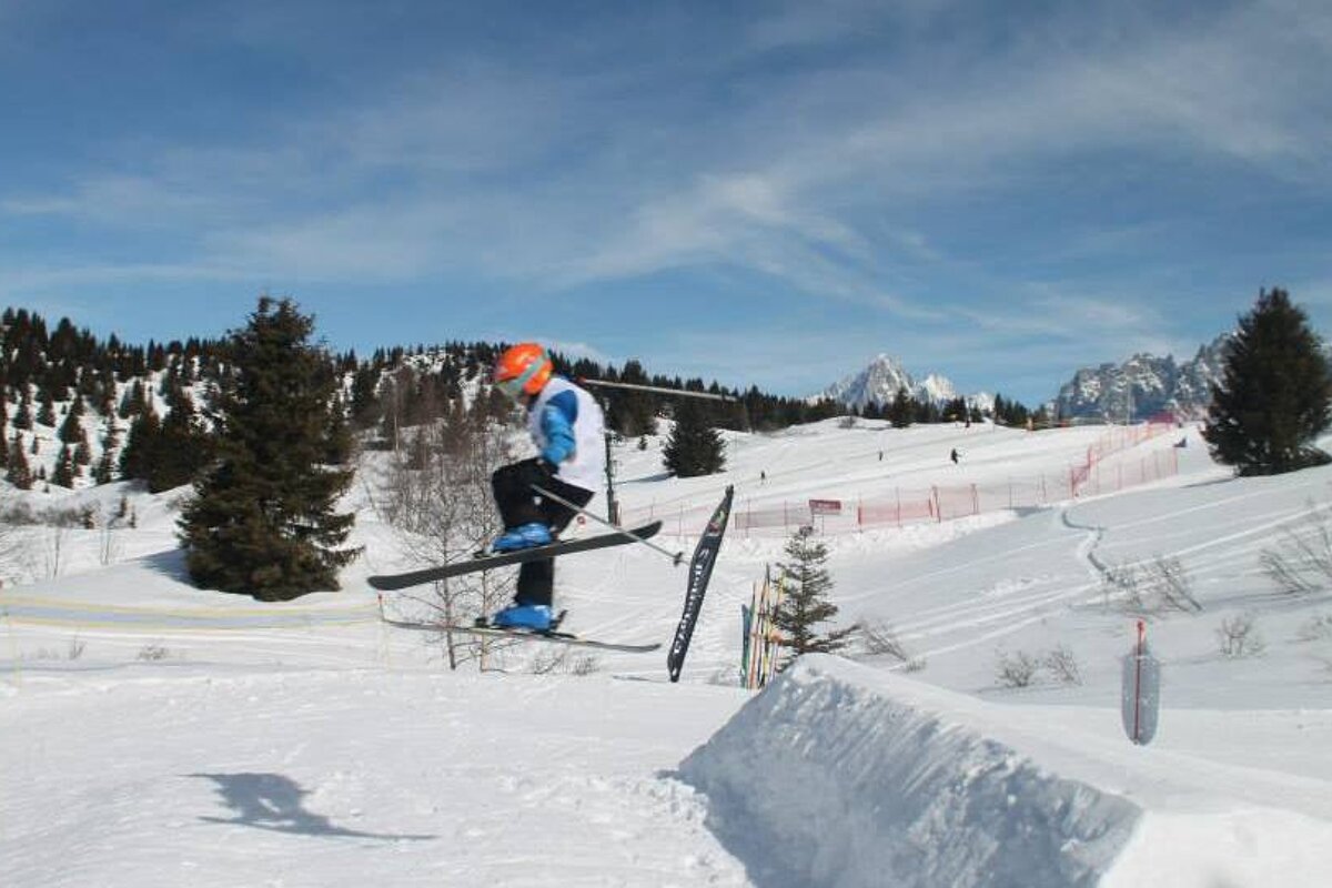 a kid skiing over a jump in les houches