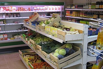 A grocery store aisle with boxes of fruits and vegetables