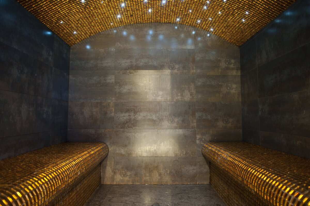 A dark room with a ceiling that has gold tiles on it