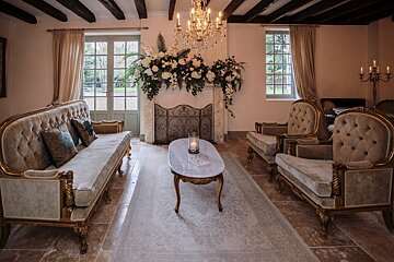 A living room with furniture and a fireplace with flowers on it