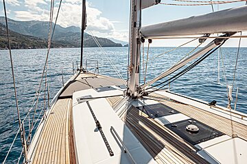 A sailboat in the ocean with mountains in the background