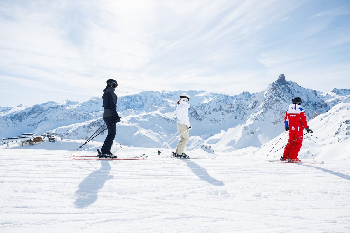 Skiers on a snowy slope with one wearing a red jacket with the number 8 on it