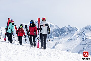 Skiers standing on top of a snow covered mountain with the word skiset on the bottom