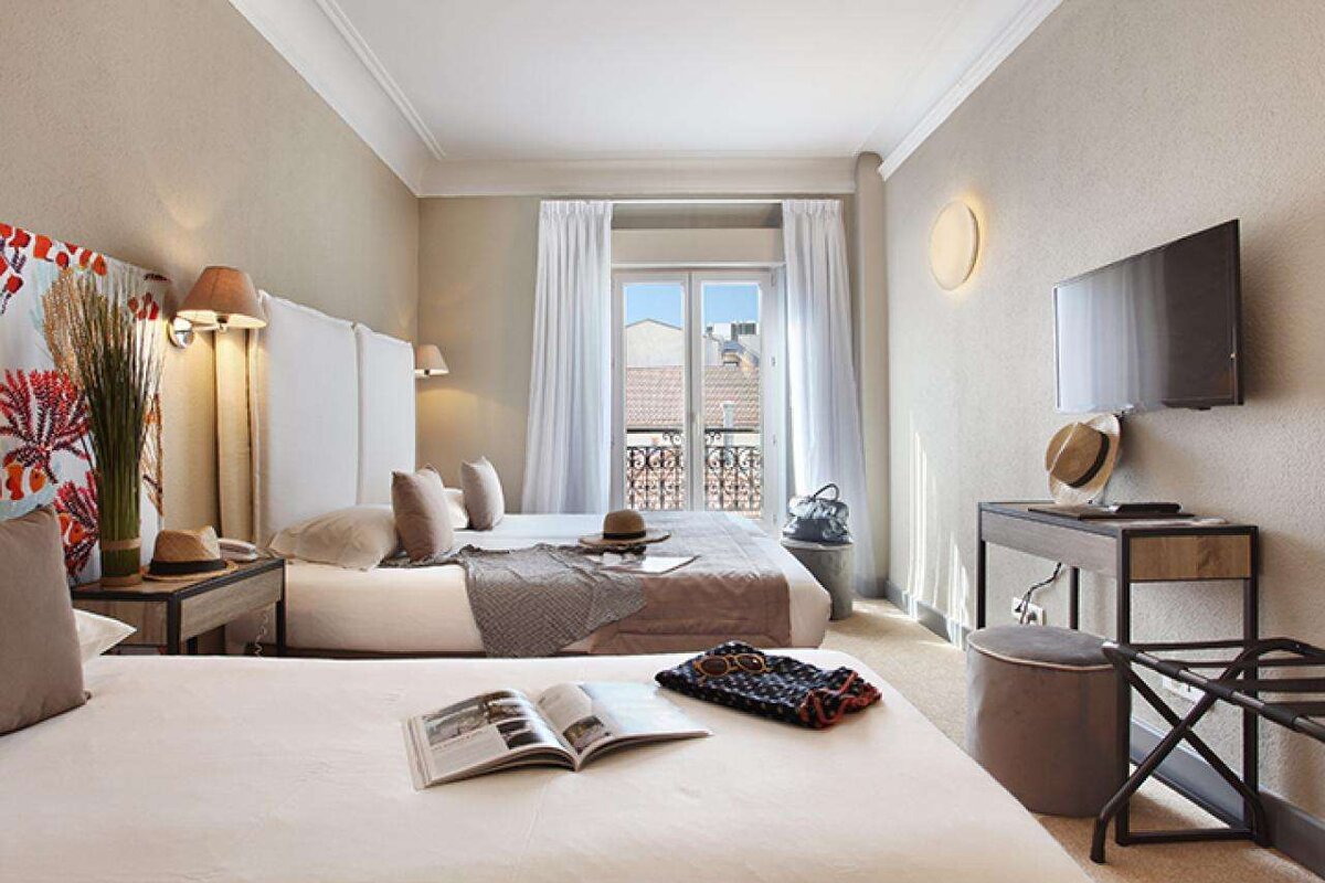 A hotel room with two beds and a flat screen tv