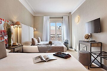 A hotel room with two beds and a flat screen tv