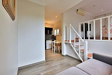 A living room with stairs leading up to the second floor
