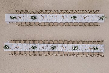 Two very long tables with flowers on them