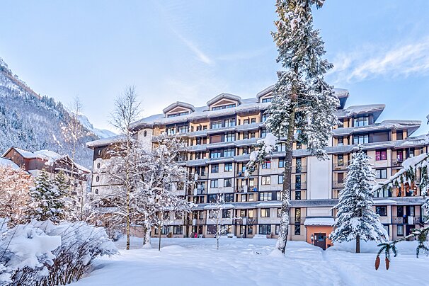 A large building with a lot of windows is covered in snow