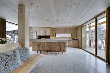 A kitchen with wooden cabinets and a concrete counter top