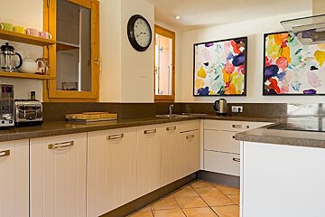 A kitchen with a toaster and a clock on the wall