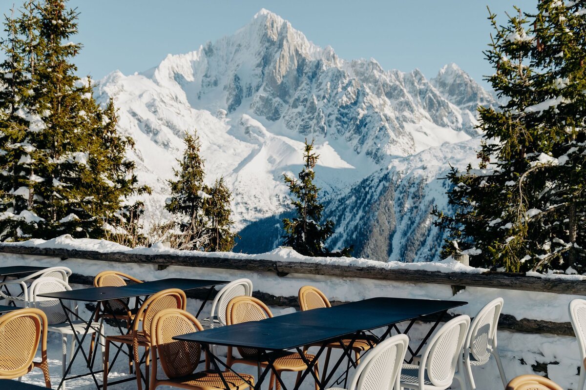 Tables and chairs in front of a snowy mountain