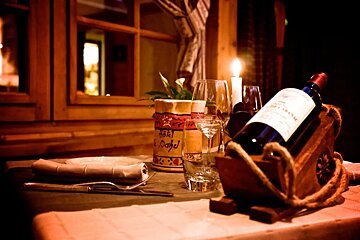 A bottle of wine sits in a wooden box on a table