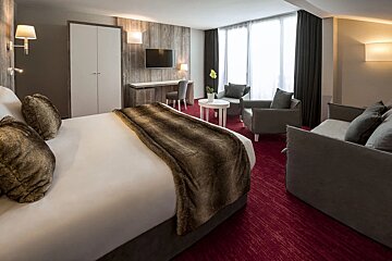 A hotel room with a large bed and a couch